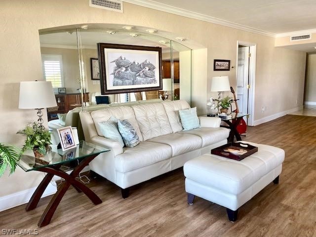 living room with hardwood / wood-style floors and ornamental molding