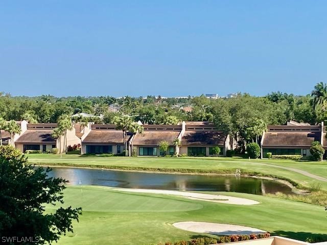 surrounding community with a water view and a lawn