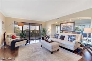 living area with ornamental molding and wood finished floors