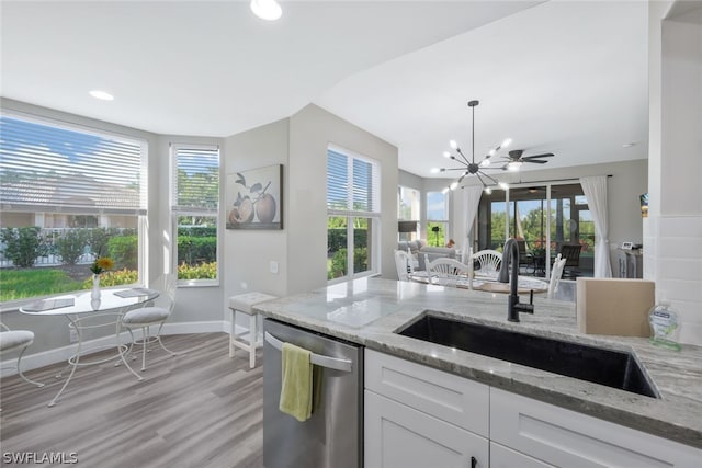 kitchen with a wealth of natural light, dishwasher, white cabinets, and sink