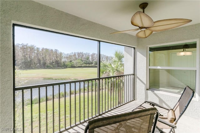 unfurnished sunroom featuring a water view and ceiling fan