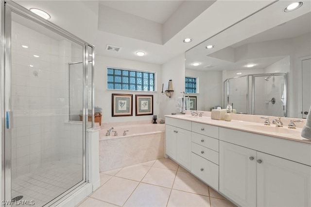 bathroom with tile patterned flooring, a tray ceiling, separate shower and tub, and vanity