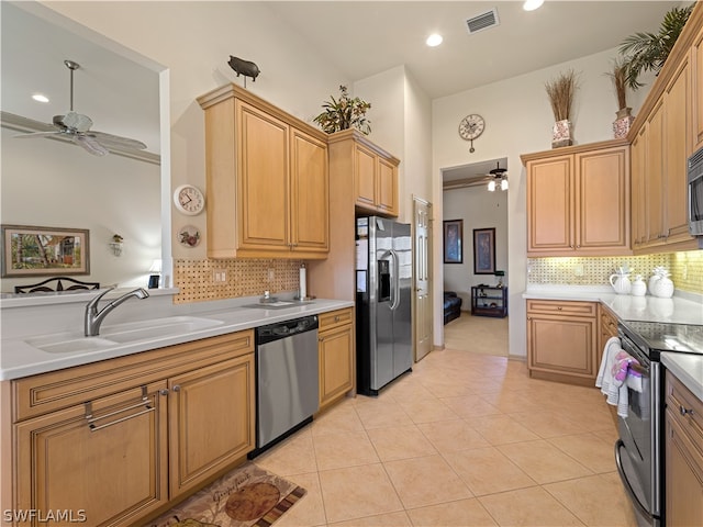 kitchen featuring ceiling fan, sink, decorative backsplash, light tile patterned flooring, and appliances with stainless steel finishes