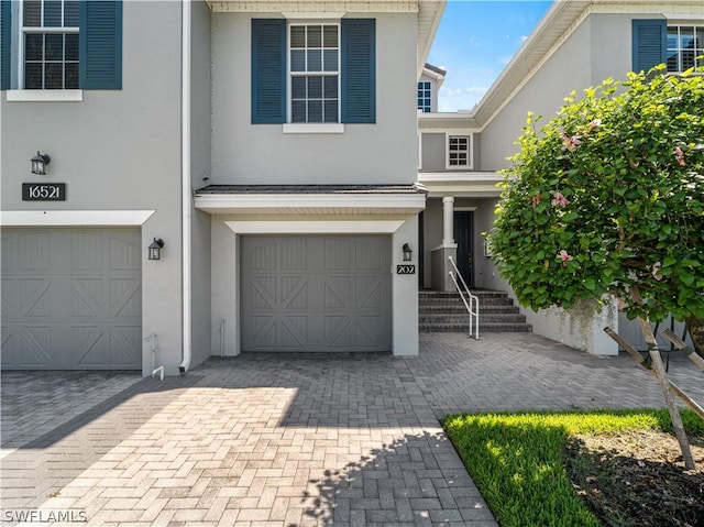 16521 Goldenrod Ln Unit 202, Alva, FL 33920 - view of front of home featuring a garage, stucco siding, and decorative driveway