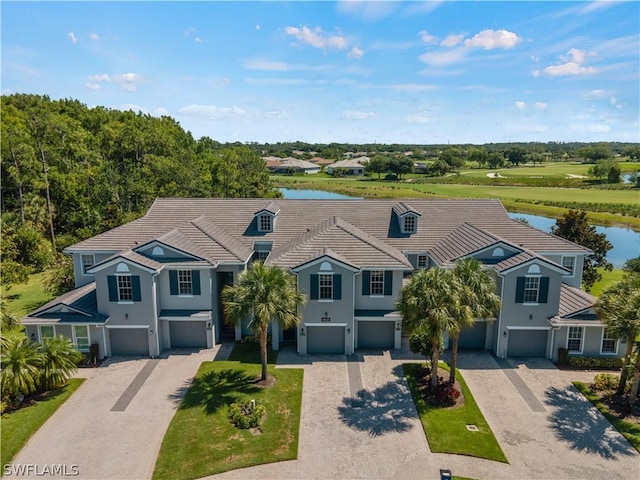 view of front of home with a garage and a water view