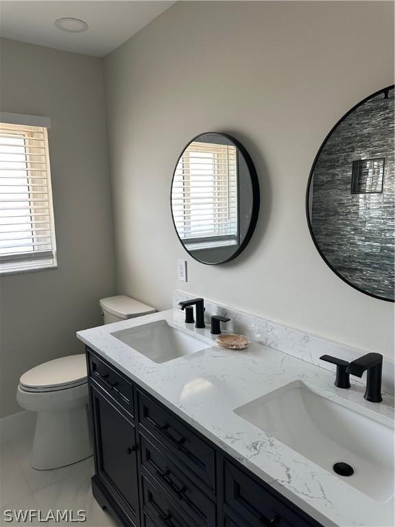 bathroom featuring a sink, a healthy amount of sunlight, and toilet