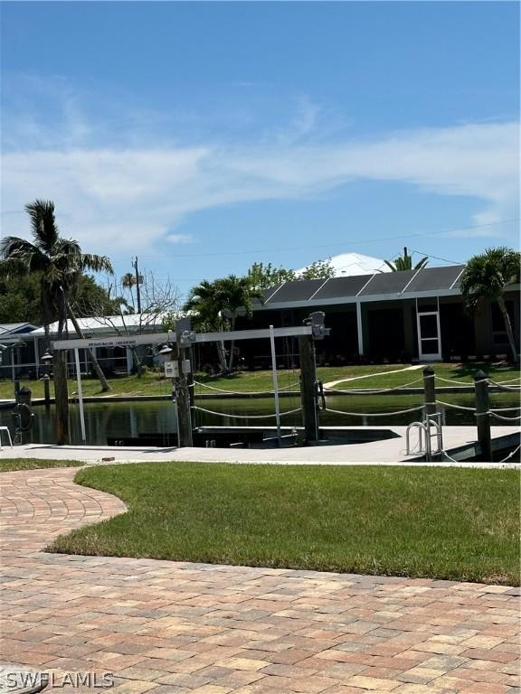 view of home's community featuring a lawn and a water view