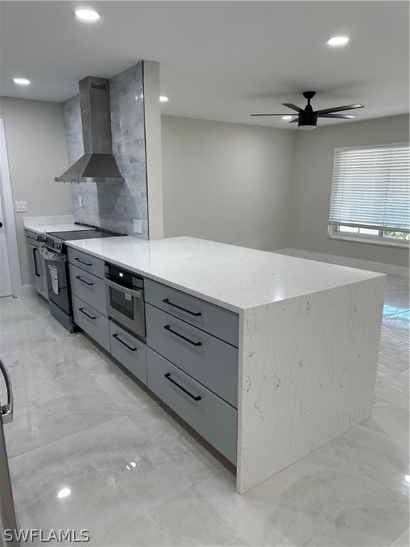 kitchen featuring wall chimney exhaust hood, modern cabinets, gray cabinetry, black electric range, and ceiling fan
