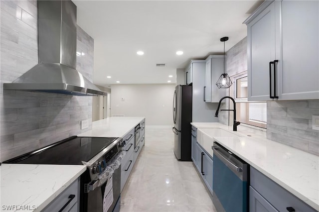 kitchen with gray cabinetry, ventilation hood, and appliances with stainless steel finishes