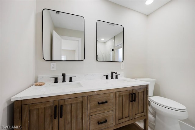 bathroom with toilet, a sink, and double vanity