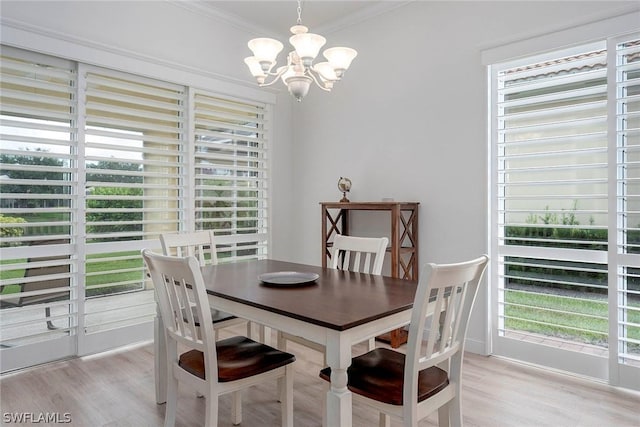 dining space with a wealth of natural light, a chandelier, and ornamental molding