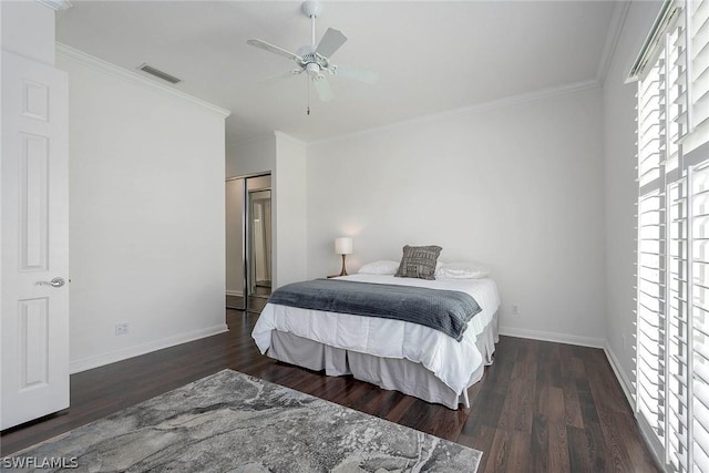 bedroom featuring ceiling fan, ornamental molding, dark wood-type flooring, and a closet