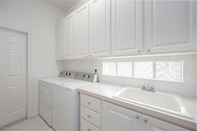 laundry area with cabinets, separate washer and dryer, sink, and light tile patterned floors