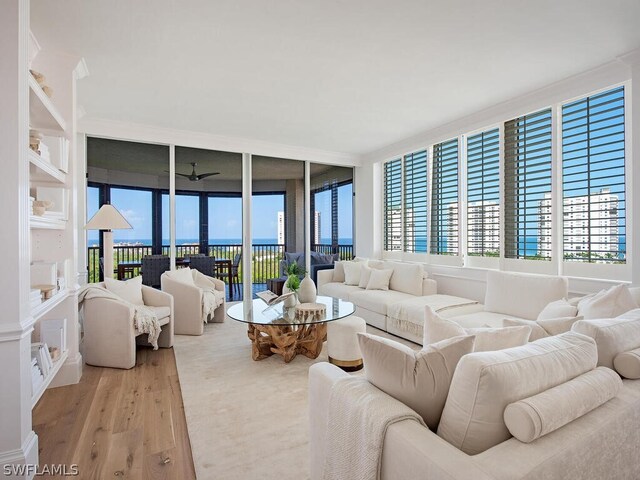 living room featuring a wall of windows and light hardwood / wood-style floors