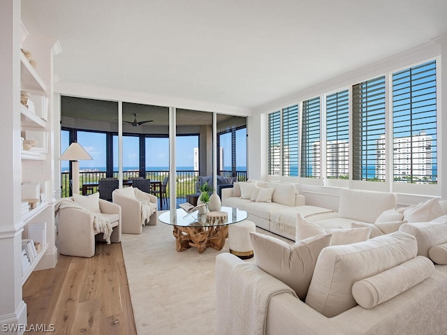 living room with expansive windows, ceiling fan, and light hardwood / wood-style floors