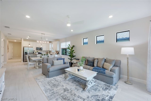 living room with ceiling fan and light hardwood / wood-style flooring