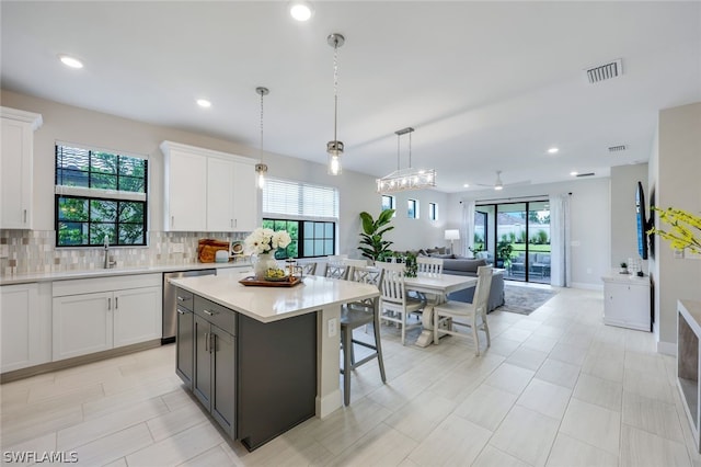 kitchen with white cabinetry, pendant lighting, and decorative backsplash