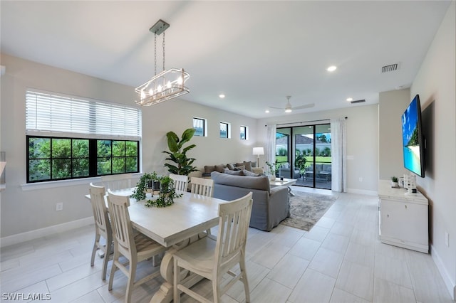 dining room featuring ceiling fan with notable chandelier