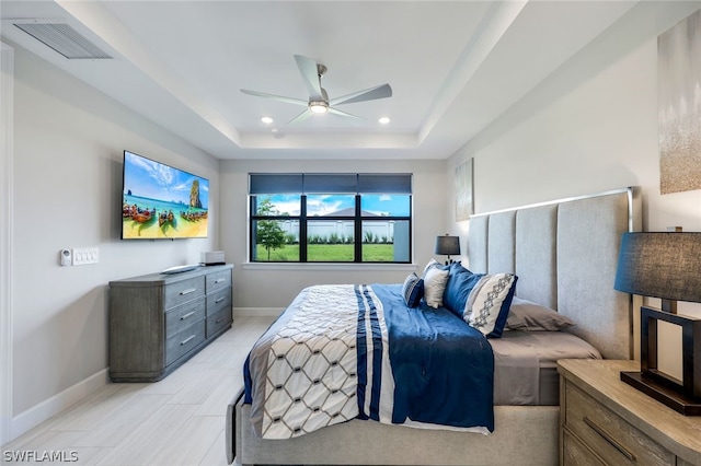 bedroom with ceiling fan and a raised ceiling