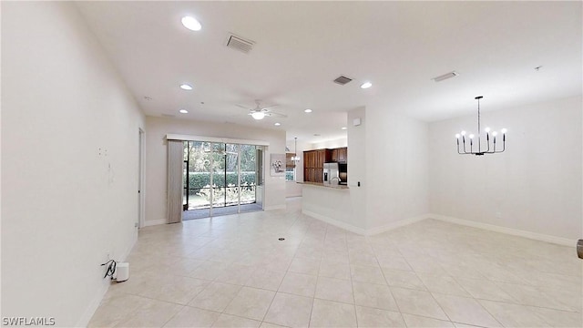 empty room featuring ceiling fan with notable chandelier and light tile patterned floors