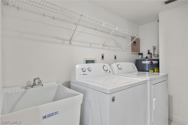 laundry area with washer and dryer, sink, and water heater