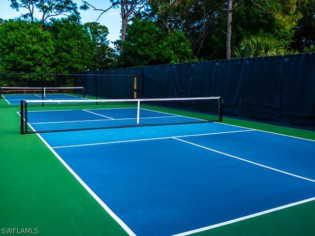 view of tennis court featuring basketball hoop