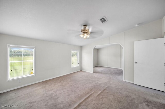 carpeted empty room with a healthy amount of sunlight and ceiling fan