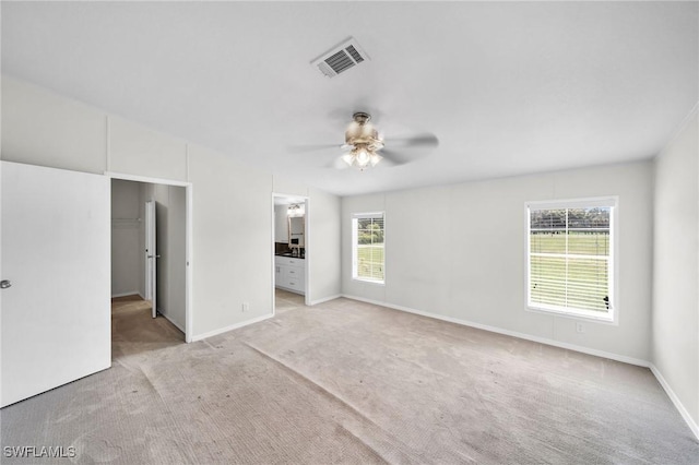 empty room with light colored carpet and ceiling fan