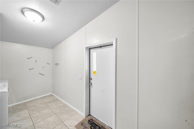 interior space featuring a textured ceiling and light tile patterned floors