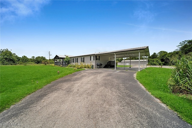 view of front of home with a carport and a front lawn