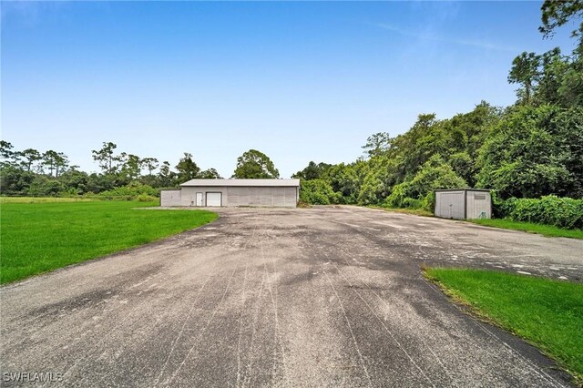 single story home featuring an outbuilding and a front lawn