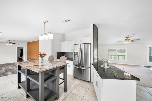 kitchen with white cabinetry, light carpet, ceiling fan, and stainless steel fridge