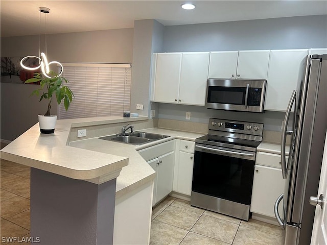 kitchen with a sink, appliances with stainless steel finishes, a peninsula, and light tile patterned flooring