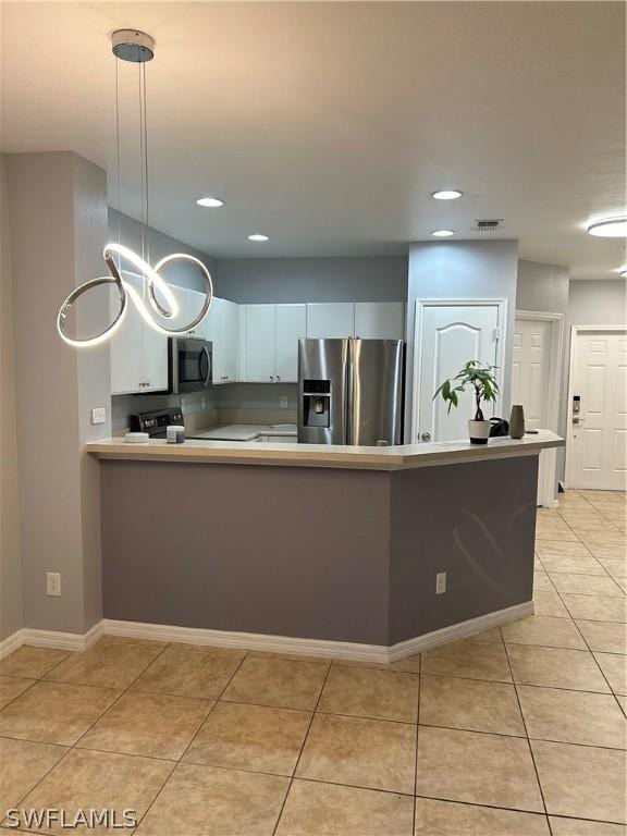 kitchen with a peninsula, stainless steel fridge, light countertops, recessed lighting, and light tile patterned floors