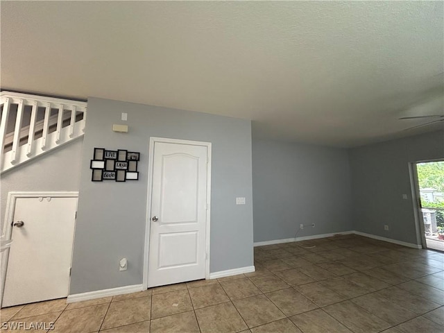 unfurnished room featuring tile patterned flooring, ceiling fan, and baseboards
