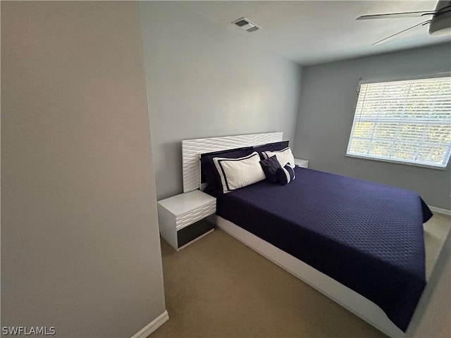 carpeted bedroom with visible vents, a ceiling fan, and baseboards