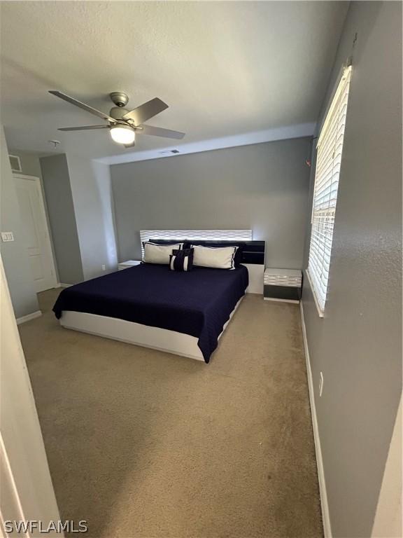 bedroom with carpet floors, a ceiling fan, baseboards, and visible vents