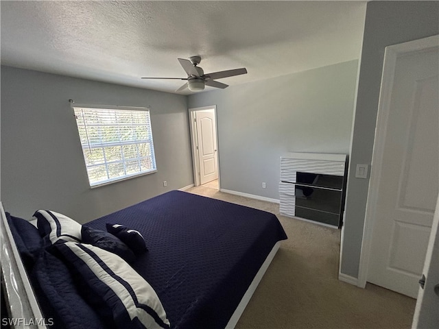 bedroom with ceiling fan, a textured ceiling, and light carpet