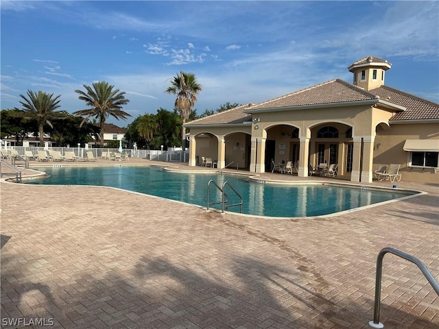 pool with a patio and fence