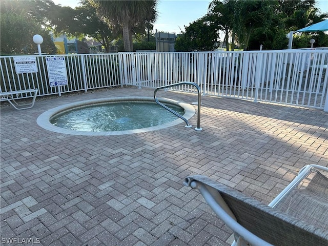 view of pool featuring fence and a hot tub