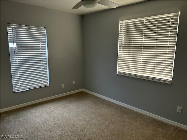 spare room featuring carpet flooring, a ceiling fan, and baseboards