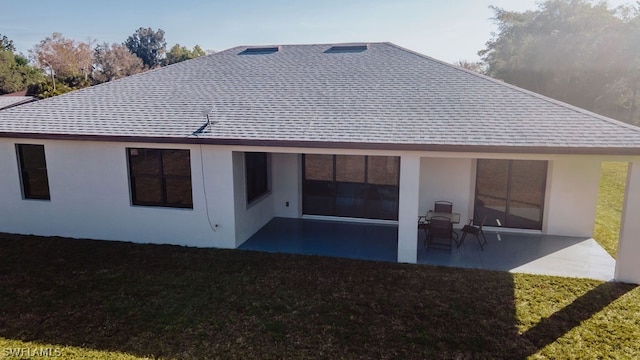 rear view of property featuring a patio area and a lawn