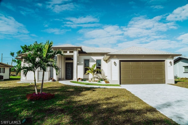 view of front of home with a front yard and a garage