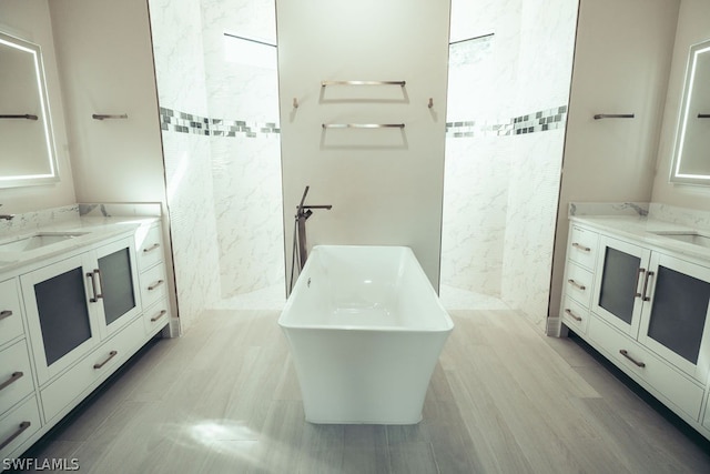 bathroom featuring tile flooring, vanity, and a bath to relax in