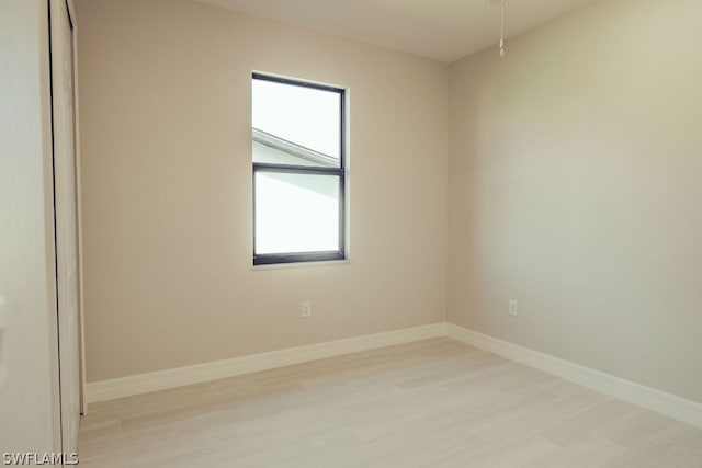 spare room featuring a healthy amount of sunlight and light hardwood / wood-style flooring