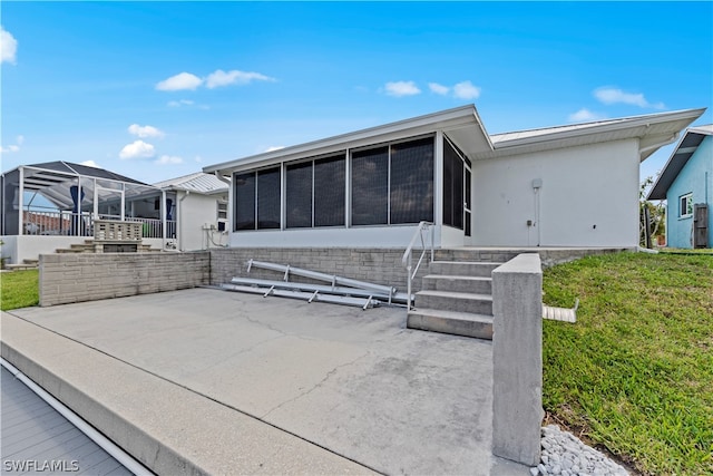 exterior space featuring a front lawn and a patio area