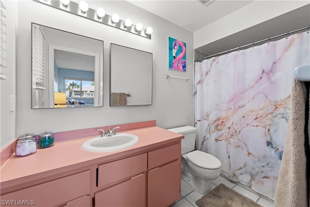 bathroom featuring tile patterned flooring, vanity, toilet, and walk in shower