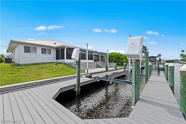 dock area featuring a lawn, central AC, and a water view