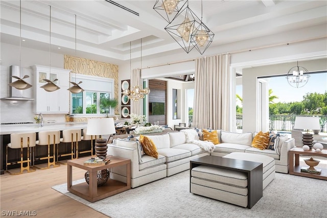 living room with a high ceiling, a tray ceiling, and light hardwood / wood-style flooring