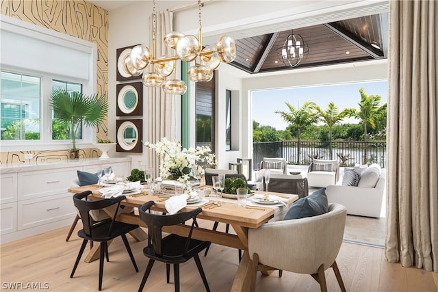 dining area featuring a chandelier, beam ceiling, light hardwood / wood-style flooring, and wooden ceiling